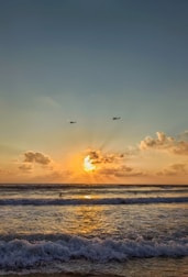 A fierce vehicle battle with helicopters and boats clashing near a fiery sunset.