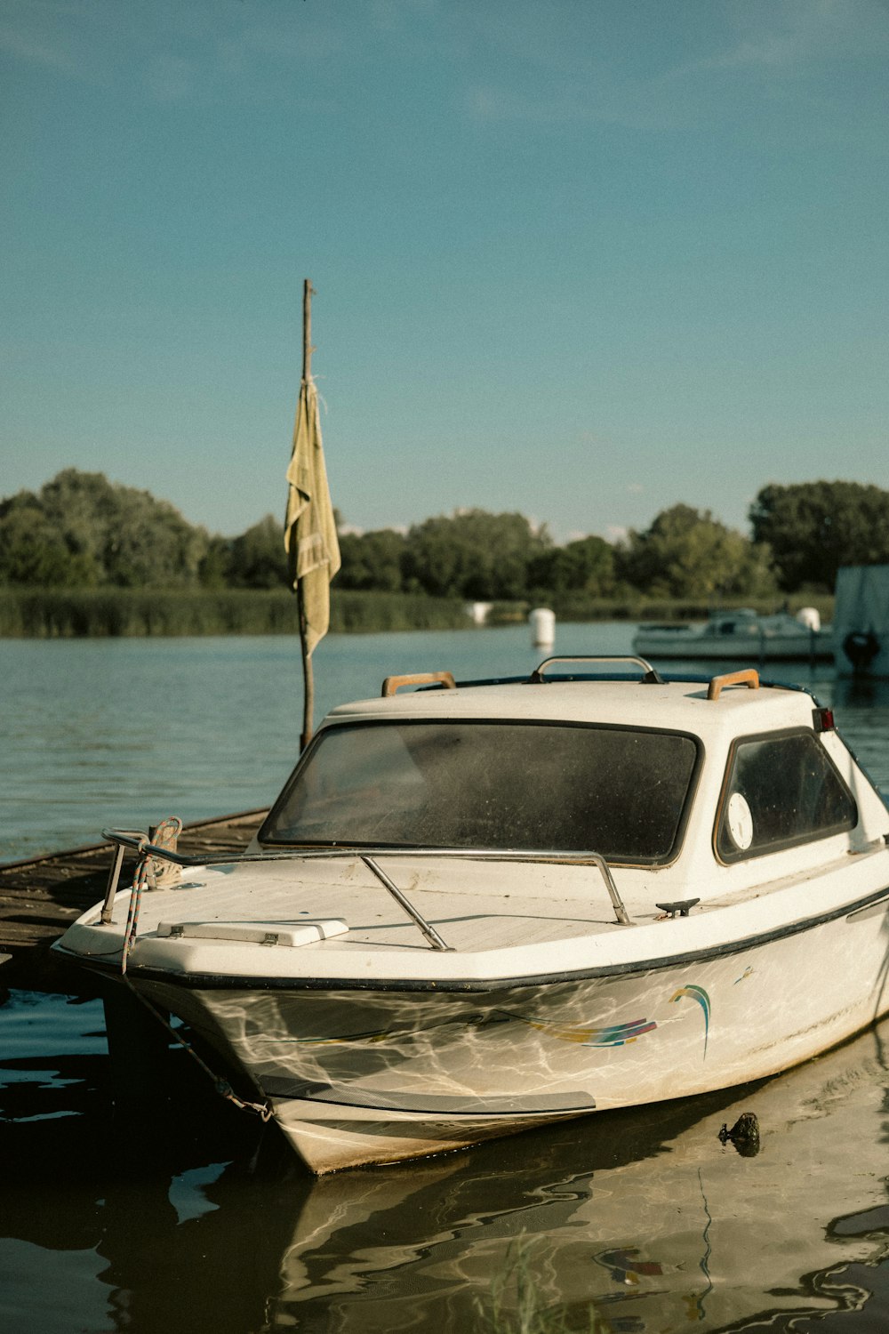 a white boat is docked at a dock