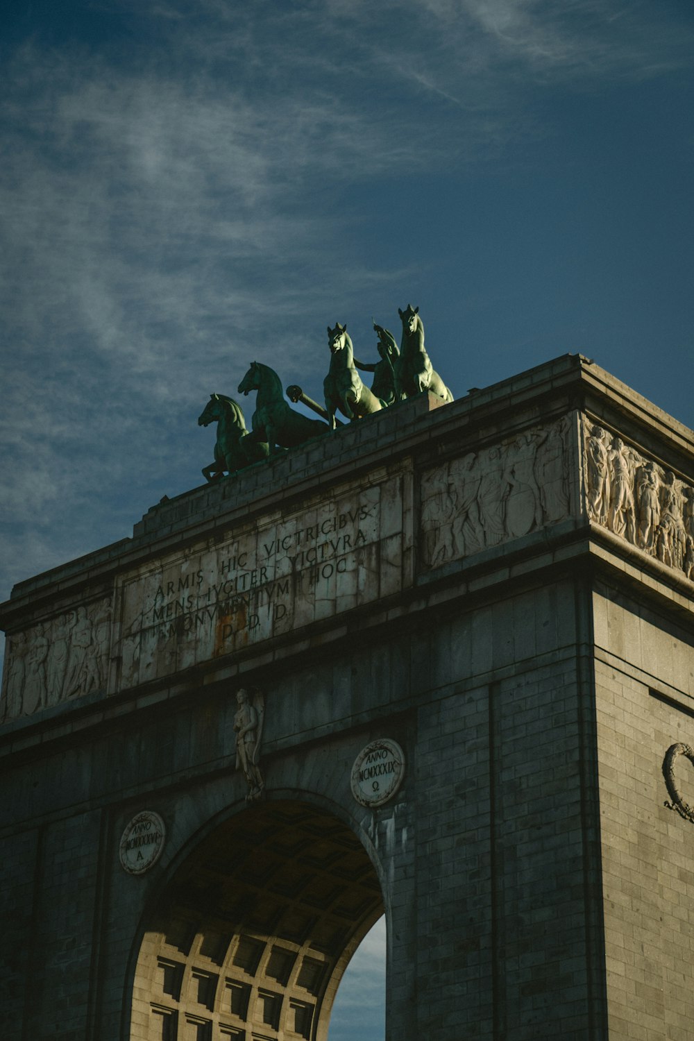 a stone arch with statues on top of it