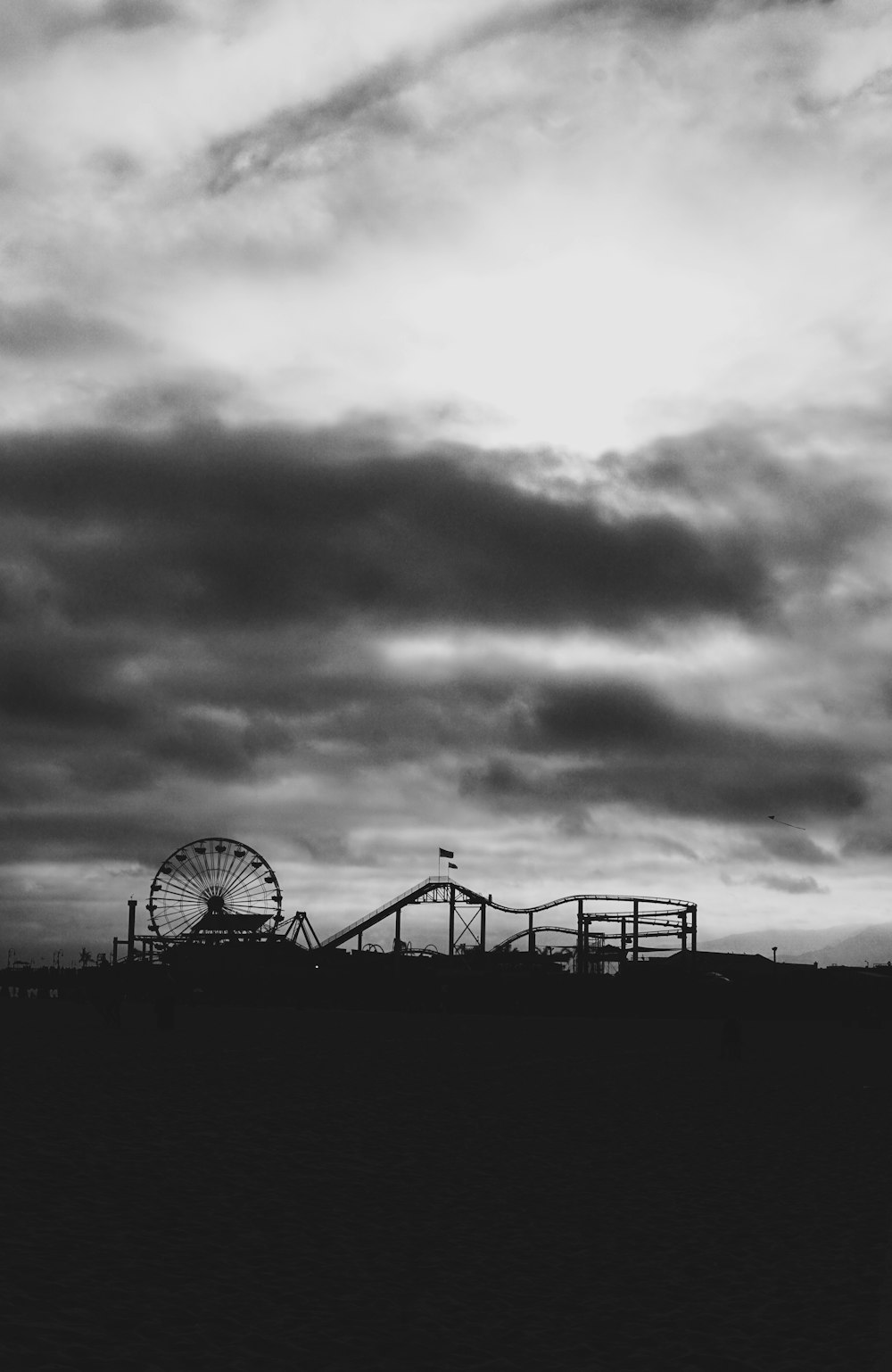 a black and white photo of a roller coaster