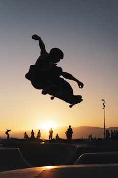 A dynamic video still showing a skateboarder mid-air against a sunset.