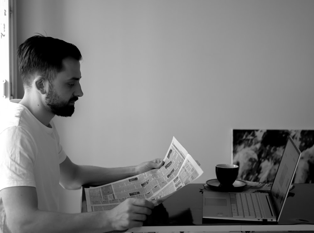 a man sitting at a desk reading a newspaper