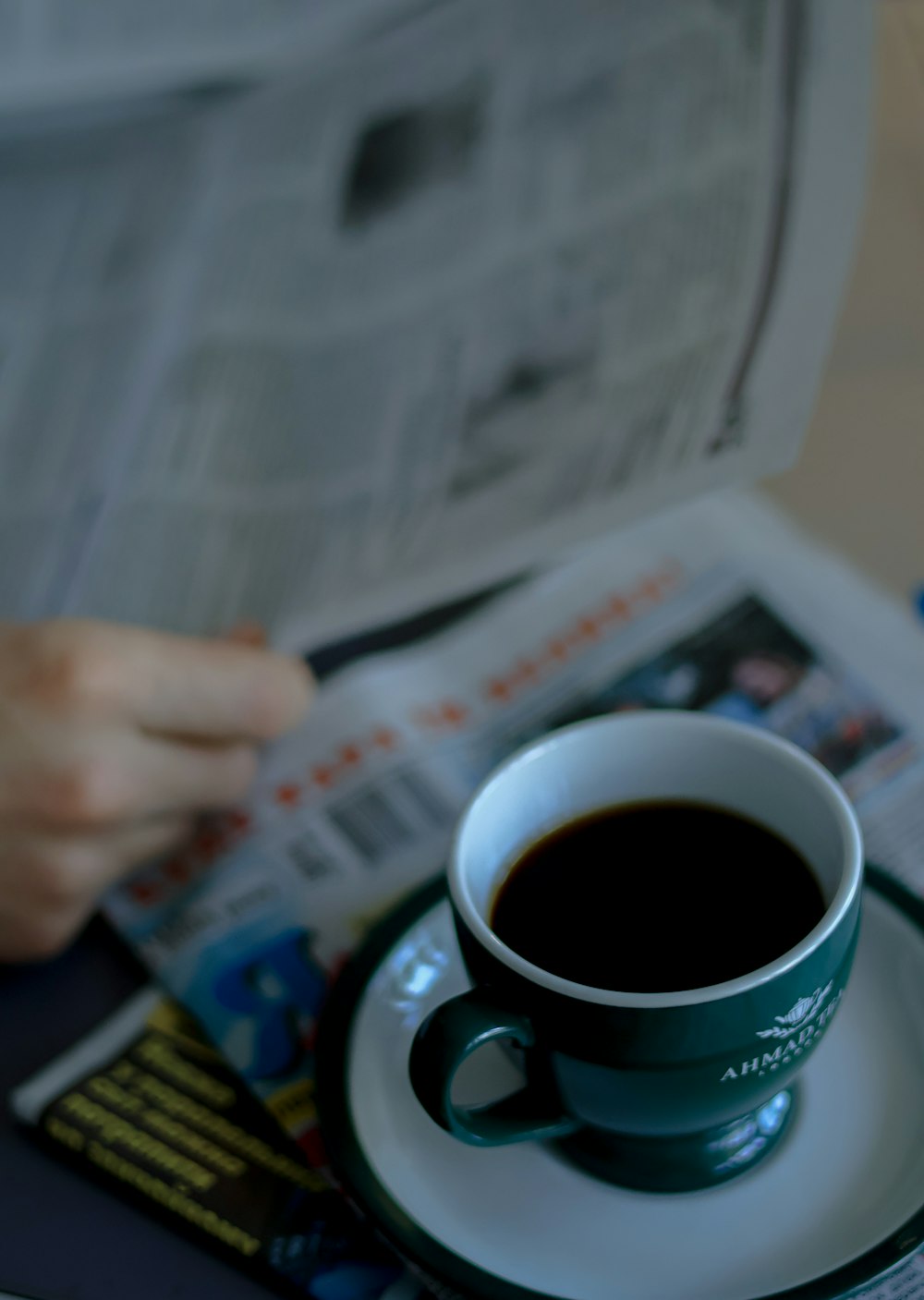 una taza de café y un periódico sobre una mesa