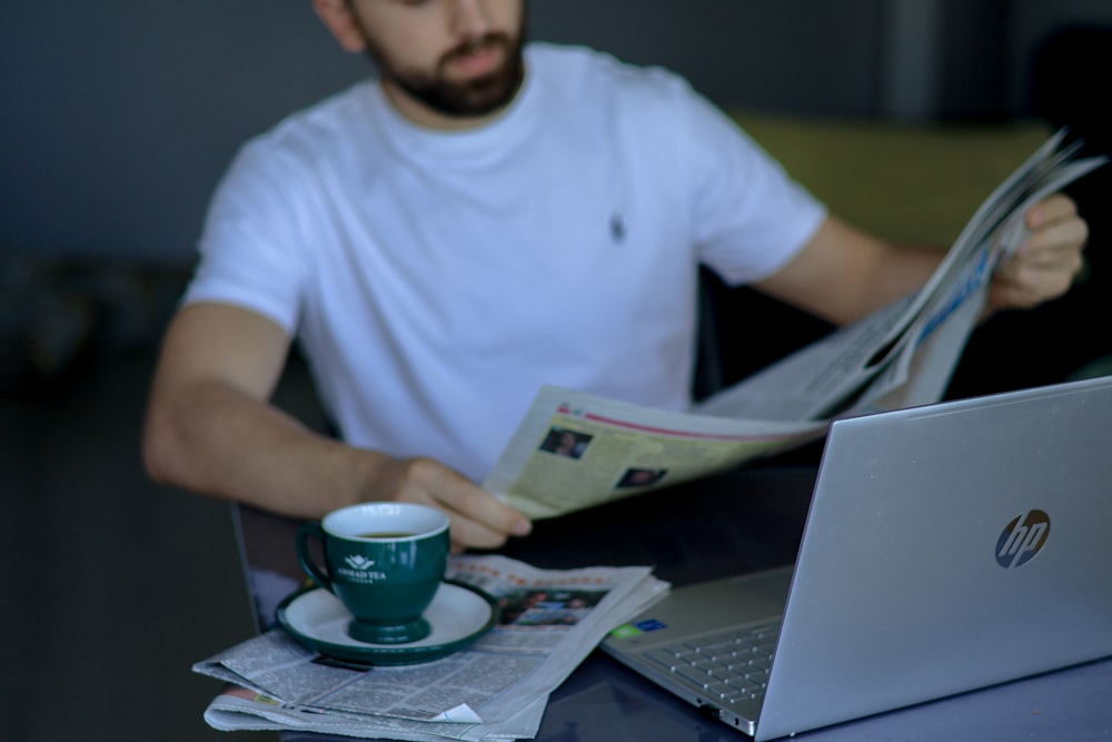 a man sitting at a table reading a newspaper