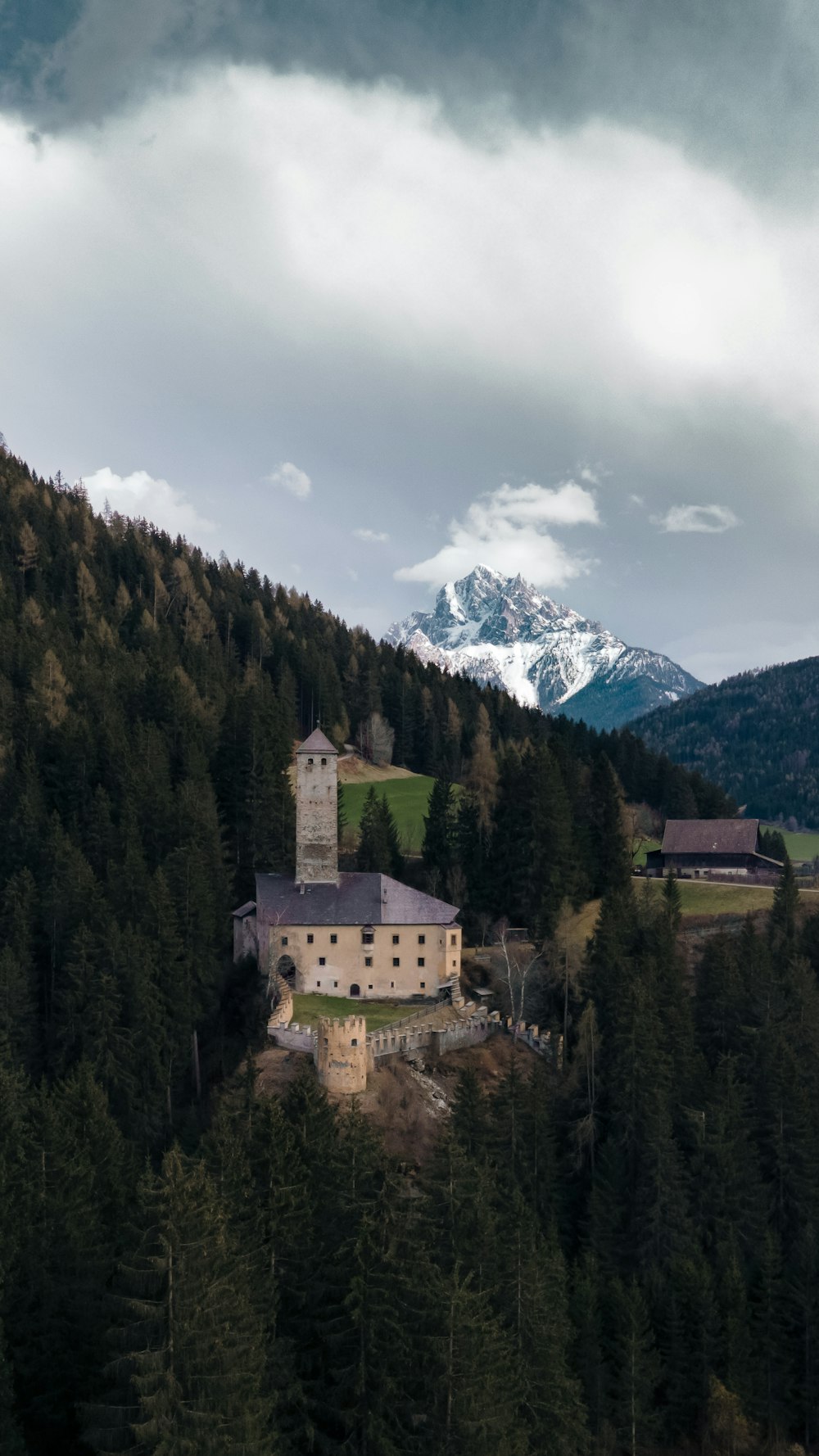 a large building sitting on top of a lush green hillside