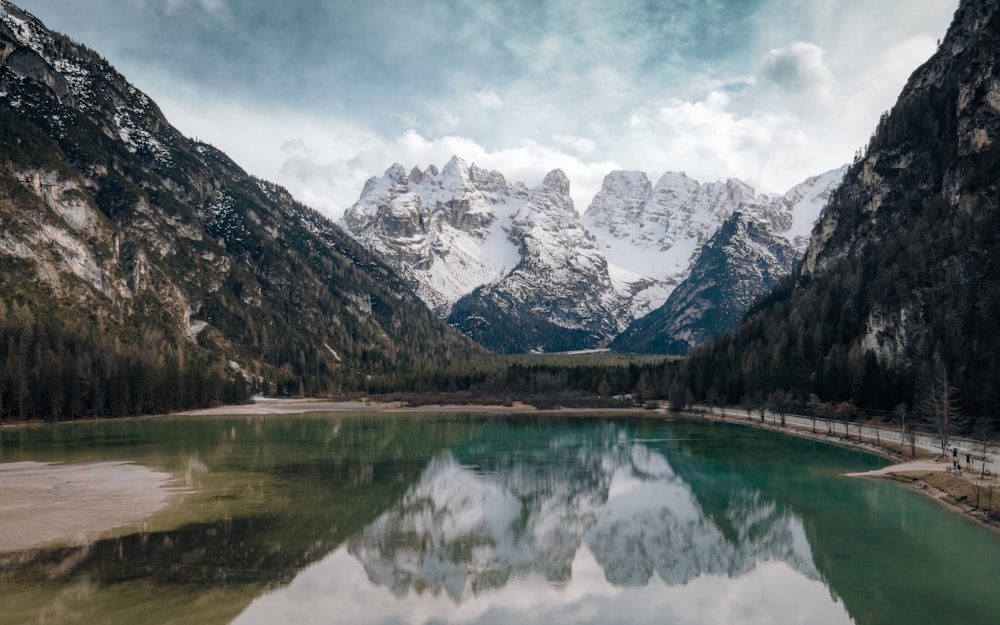 a lake surrounded by mountains and a forest