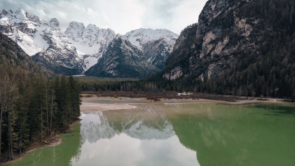 a lake surrounded by mountains in the middle of a forest