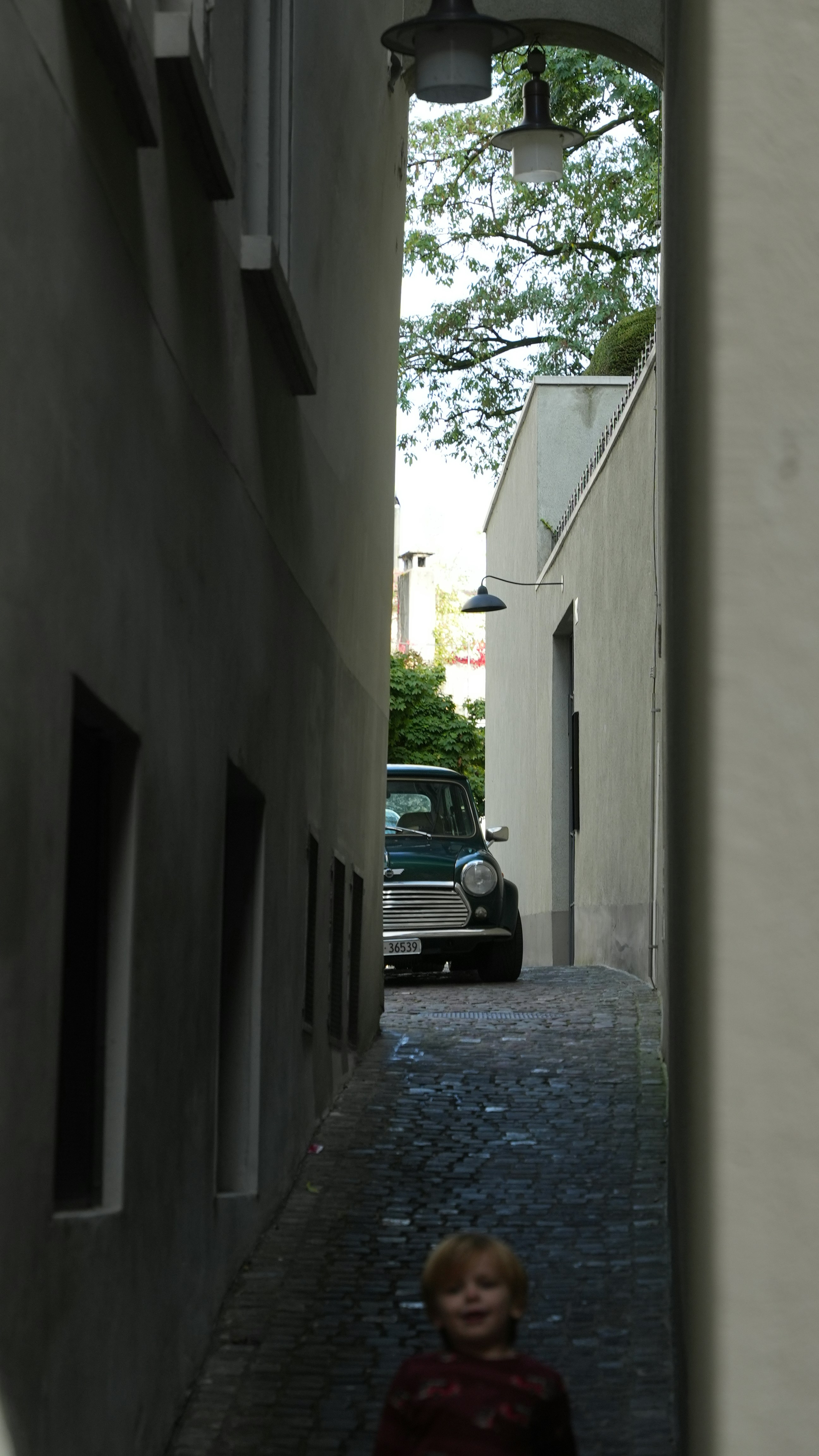 a small child walking down a narrow alley way