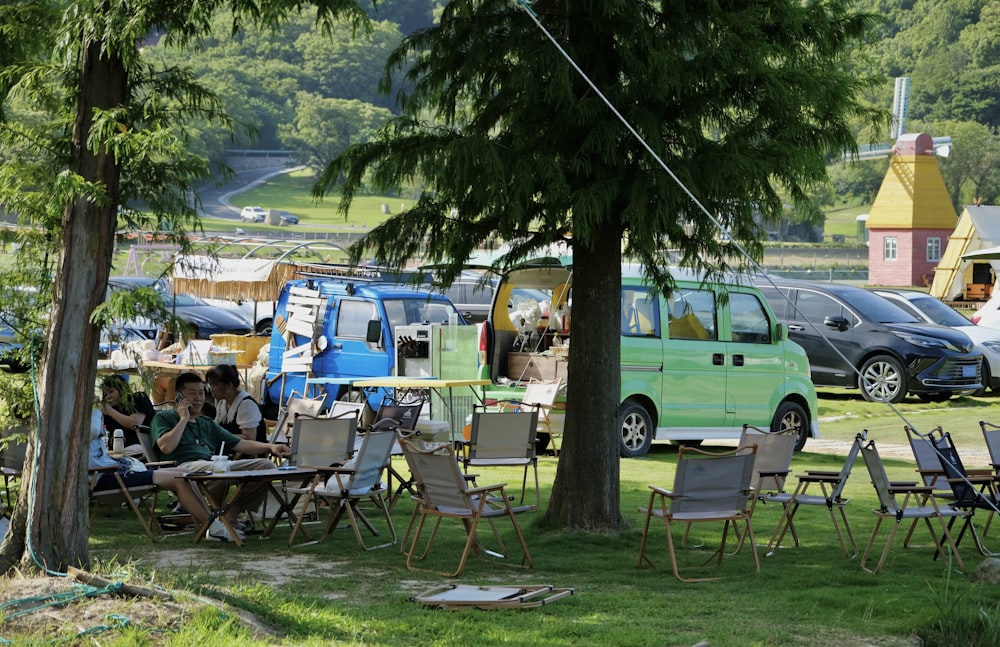 a group of people sitting at a table under a tree