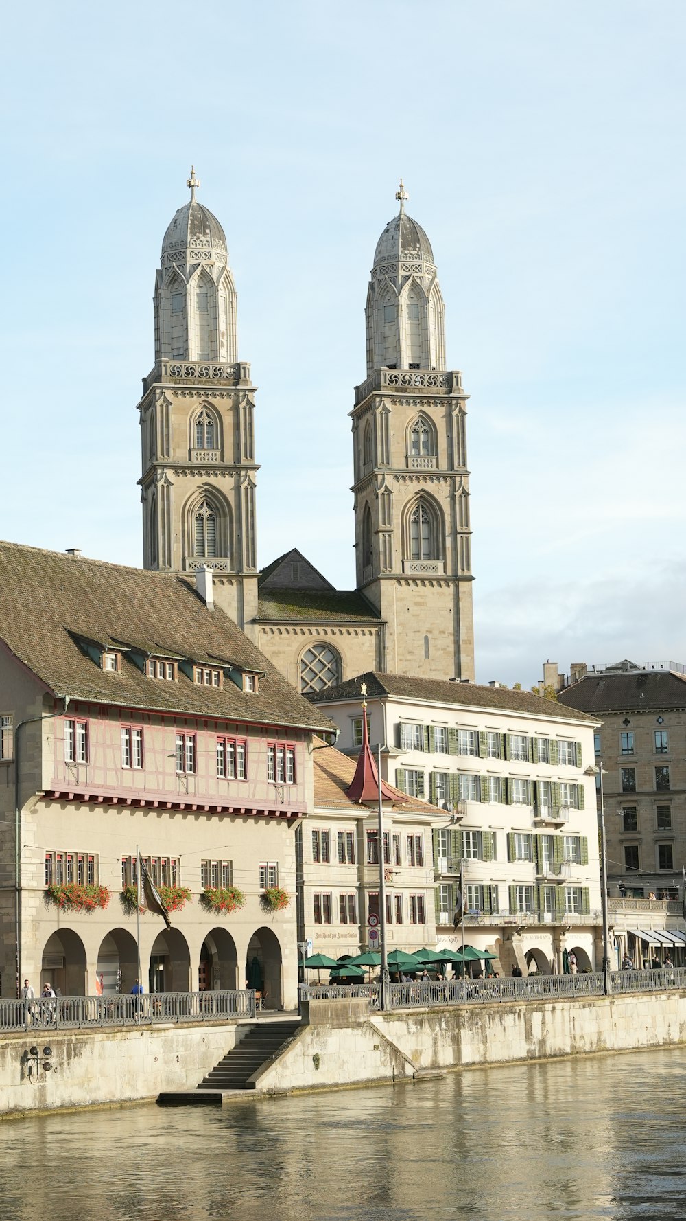 a large building with two towers next to a body of water