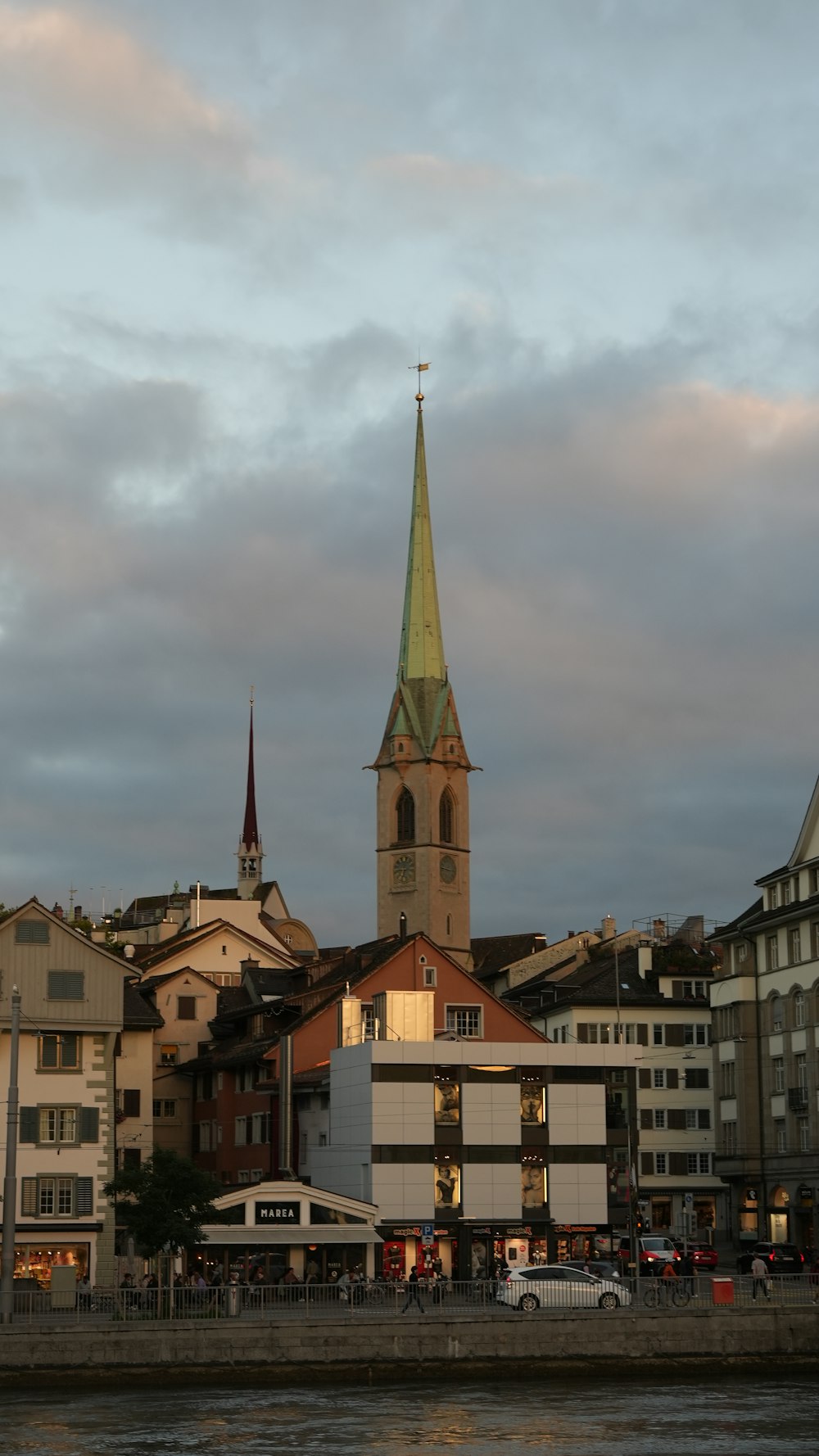 a large building with a steeple next to a body of water