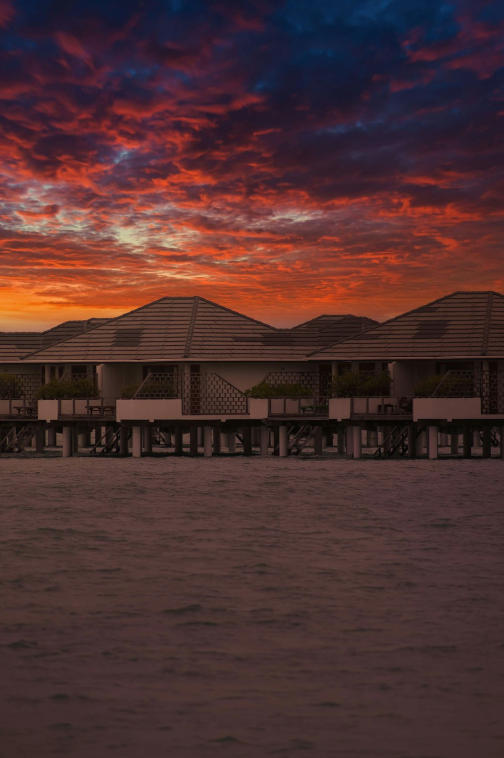 a sunset over a pier with a boat in the water