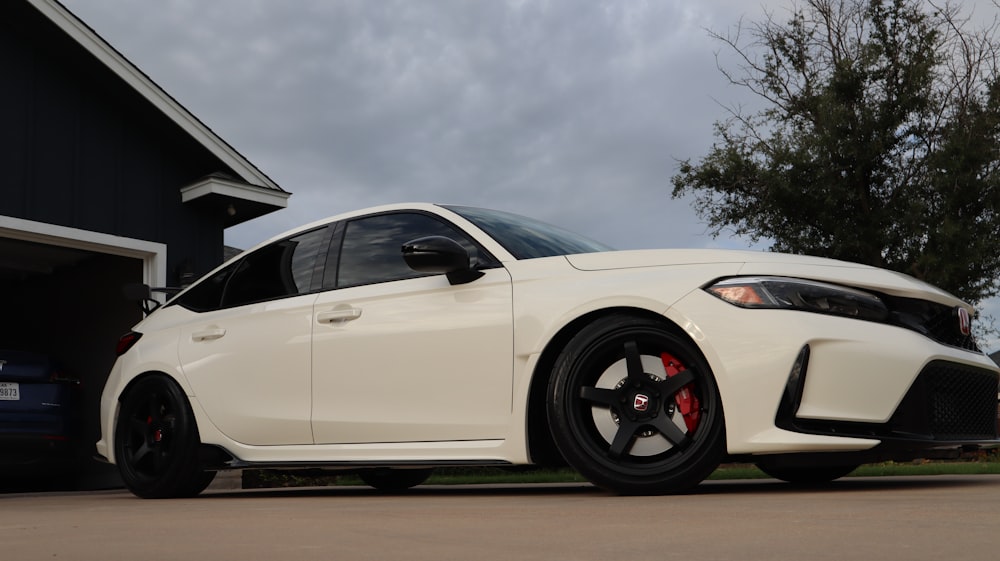 a white car parked in front of a garage