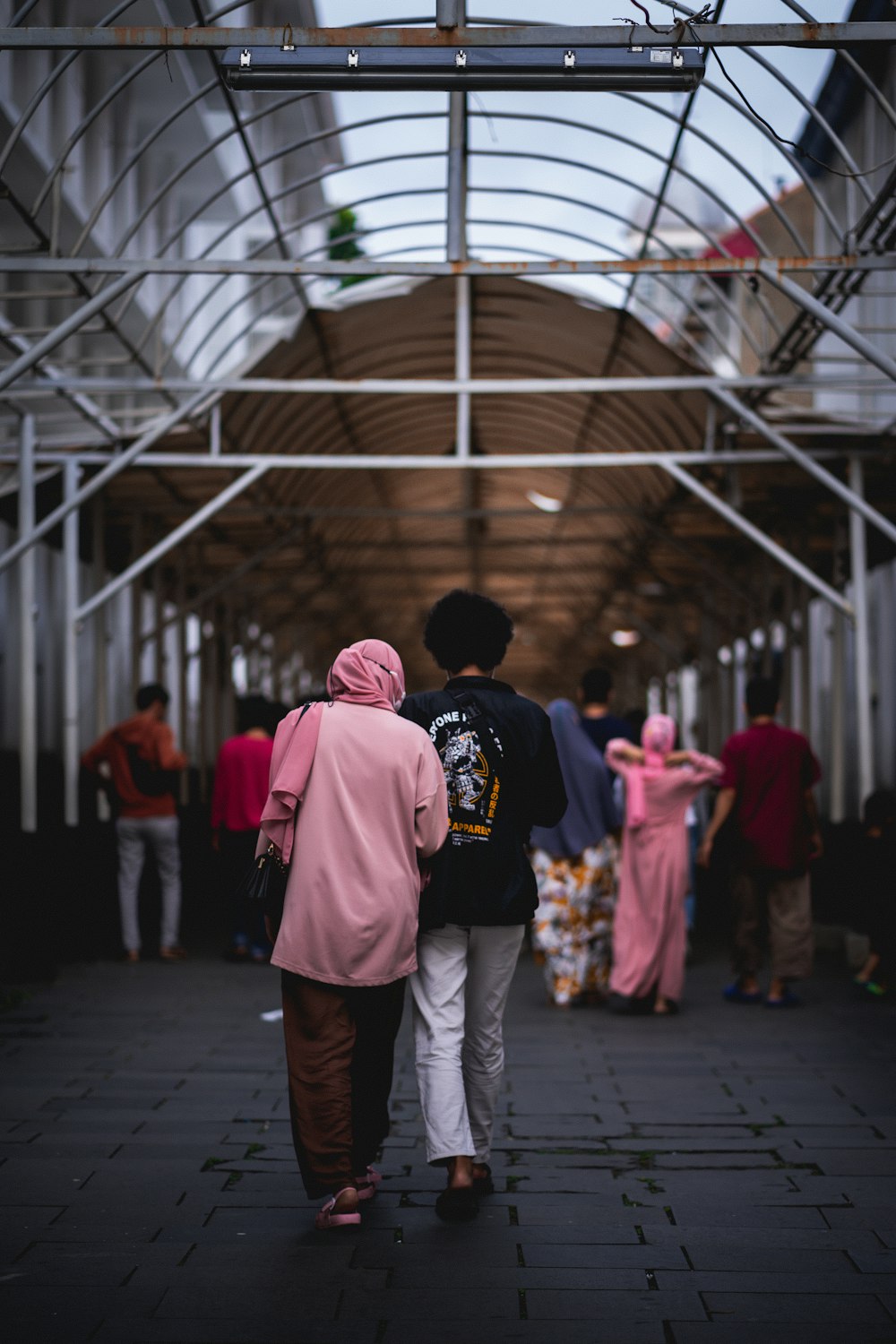 a couple of people walking down a walkway