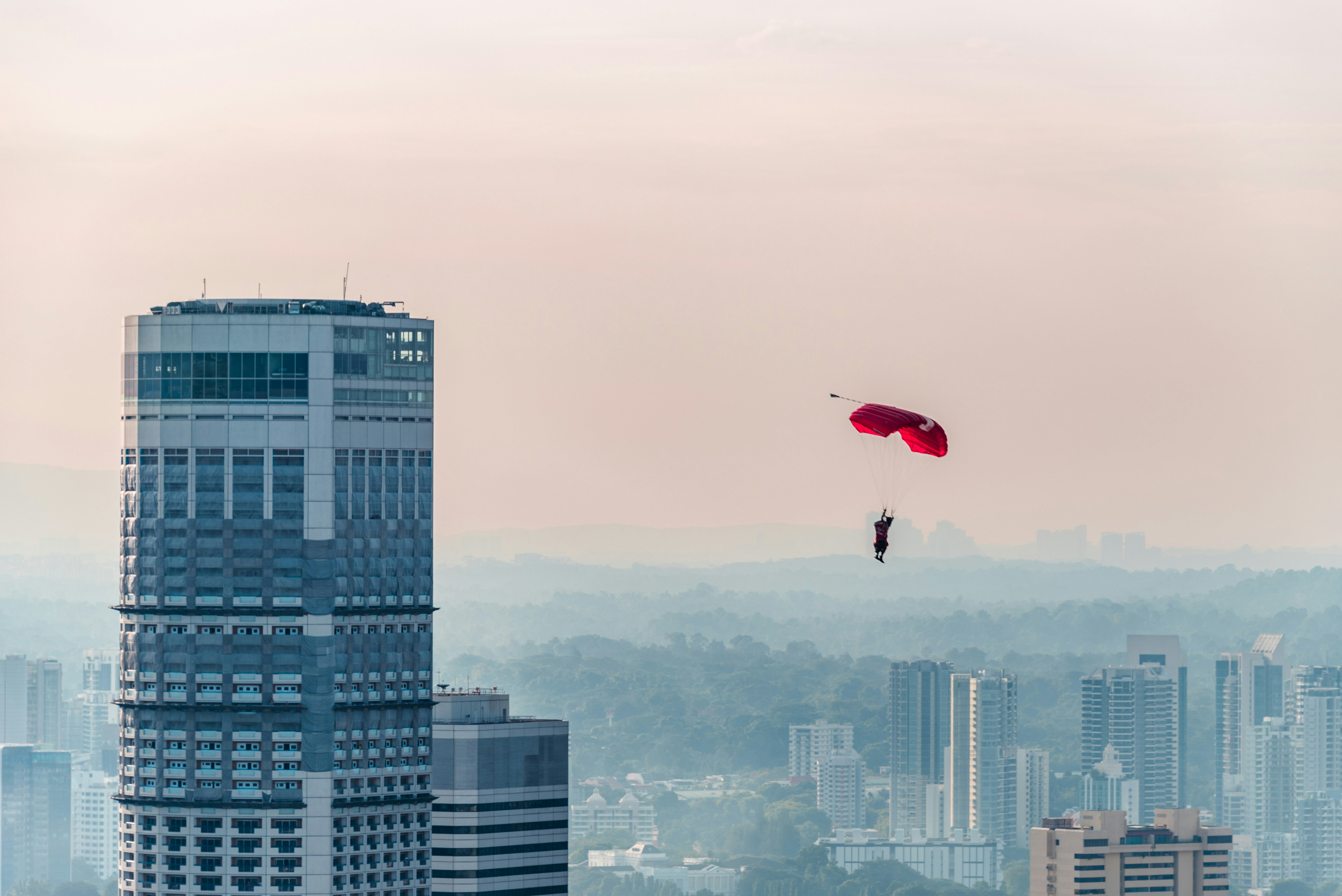 Una persona está navegando en parasailing sobre una ciudad con edificios altos
