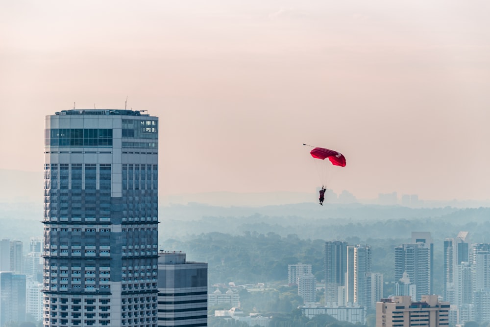a person is parasailing over a city with tall buildings