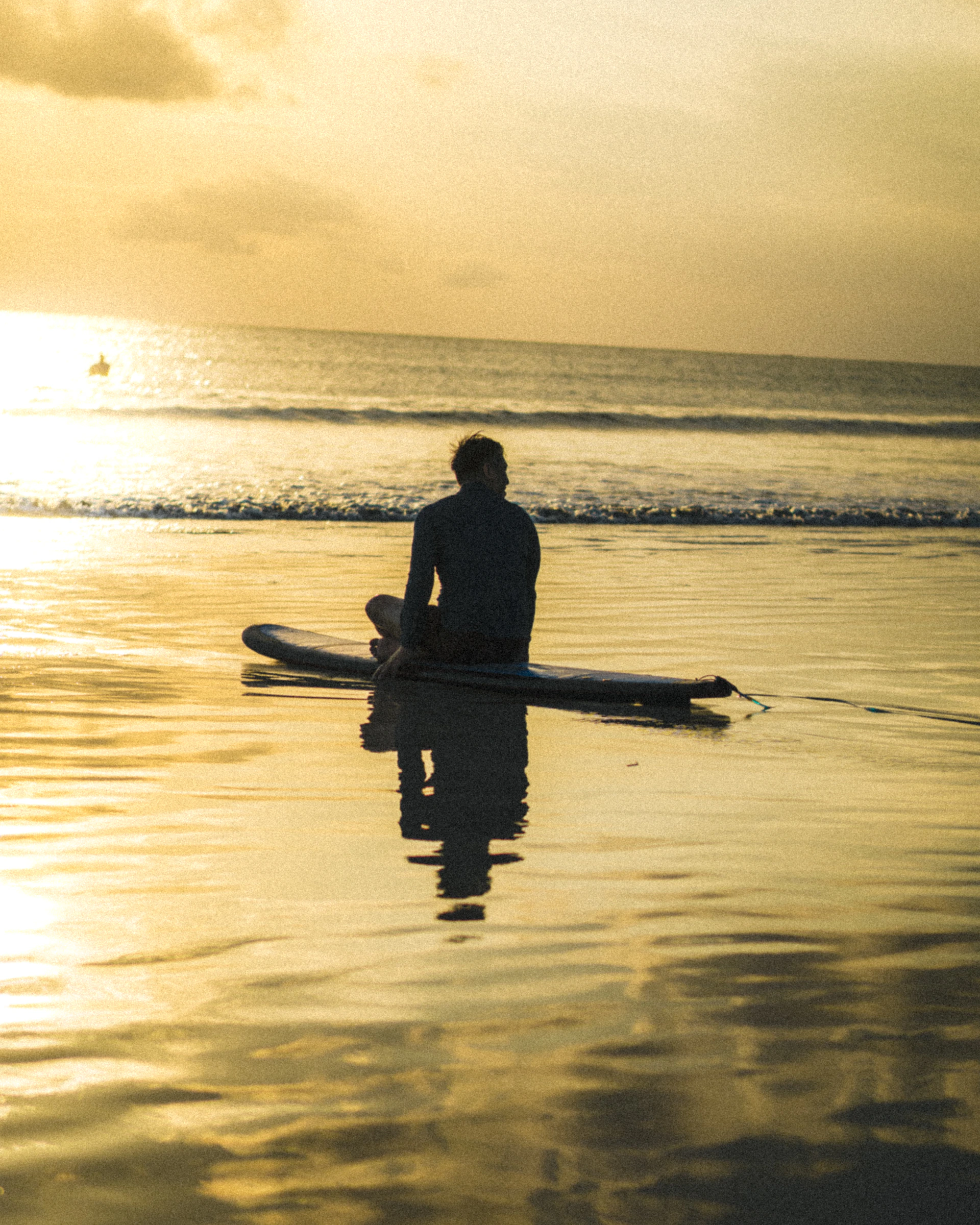 a man sitting on a surfboard in the water
