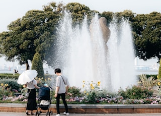 a couple of people standing in front of a fountain