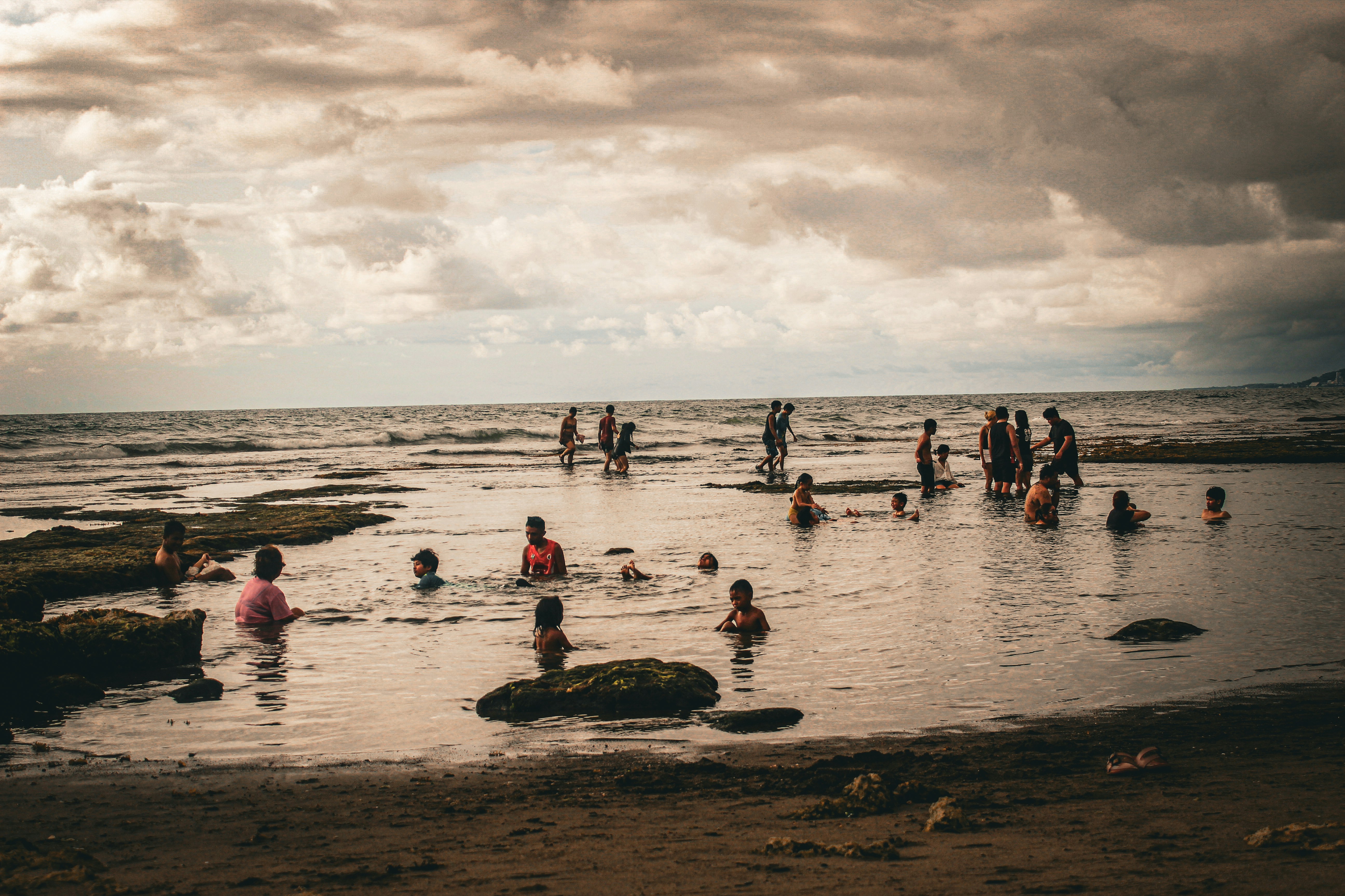 a group of people are in the water at the beach