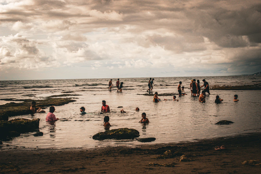 A group of people together in the water at the beach