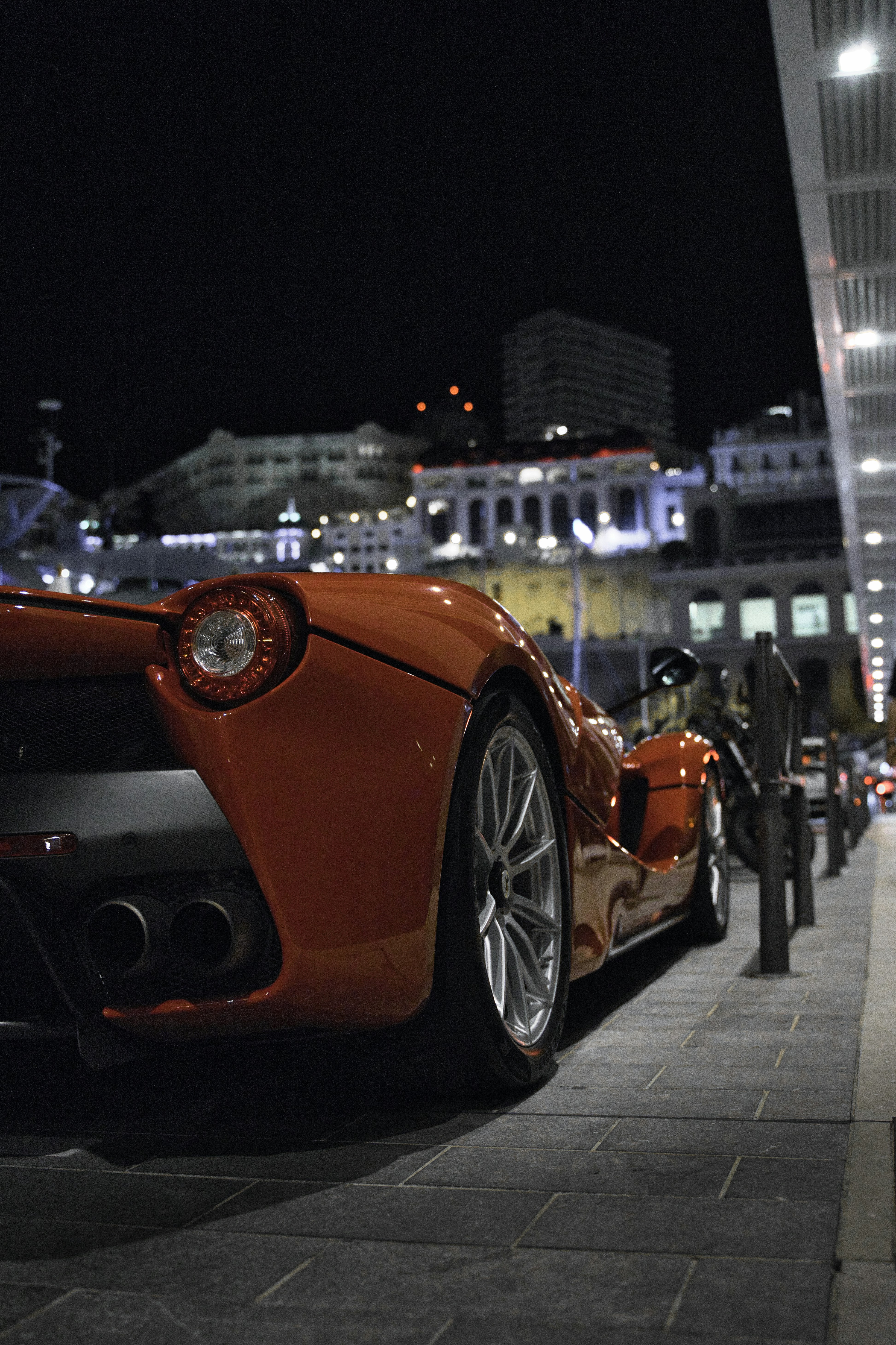 an orange sports car parked on the side of the road