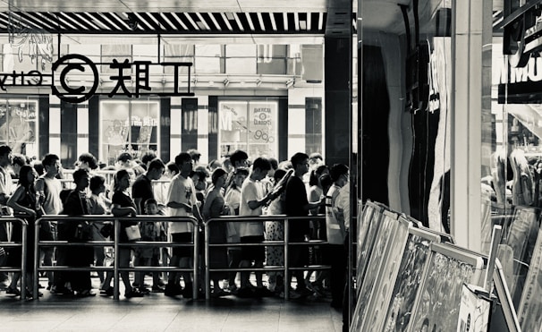 A panoramic shot capturing the photobooth setup with guests waiting in line, anticipation on their faces.