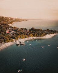 an aerial view of a beach with boats in the water