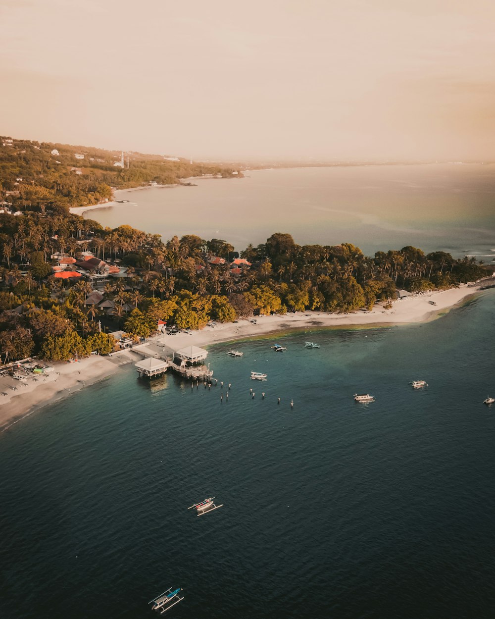 an aerial view of a beach with boats in the water