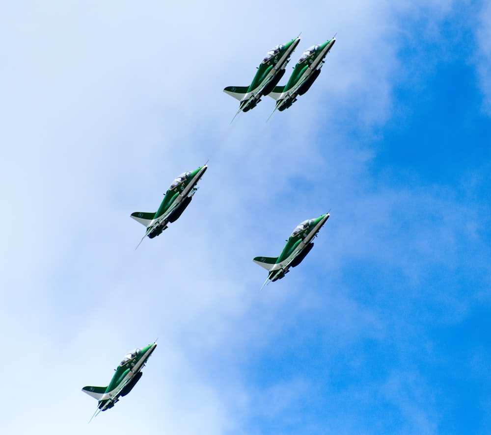 four jets are flying in formation in the sky
