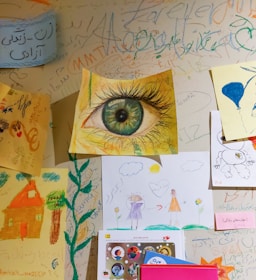 a wall covered in lots of different pictures and writing