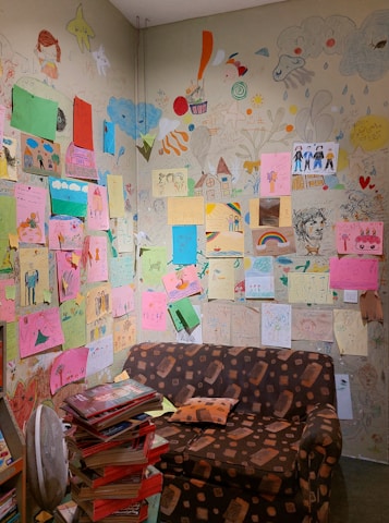 A warm, inviting room filled with art supplies and children's drawings on the walls.