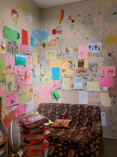 A cozy artist’s studio with colorful children's book illustrations pinned to the walls.