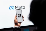 a person holding a cell phone in front of a large screen