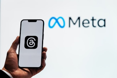 a person holding up a cell phone in front of a sign