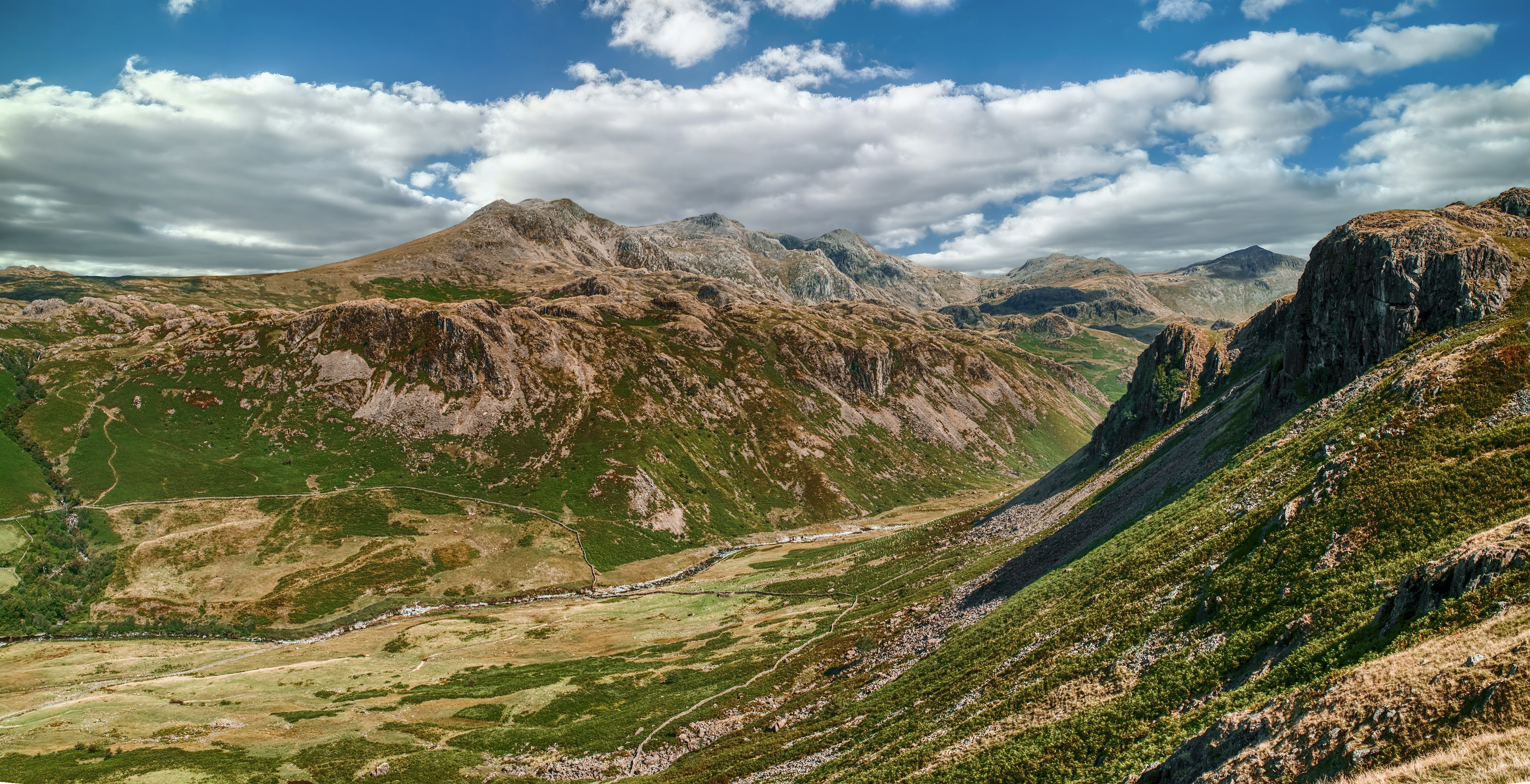 a scenic view of a valley with mountains in the background