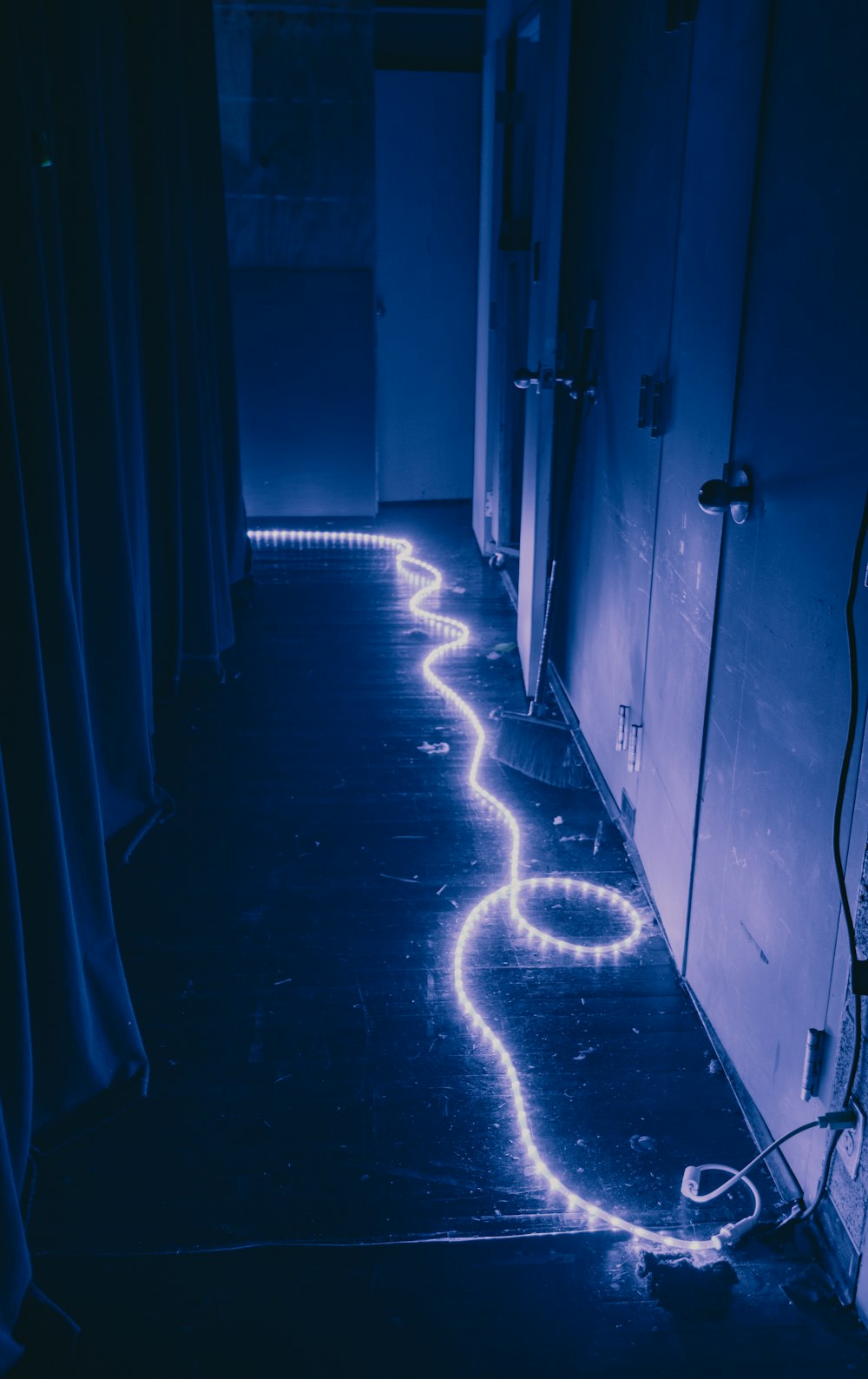 a long line of neon lights in a dark hallway