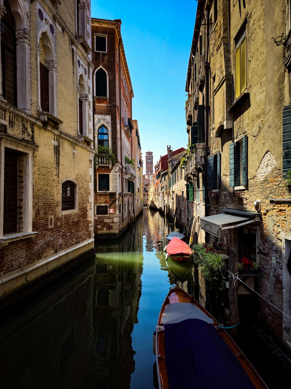 a narrow canal with a row of buildings on either side