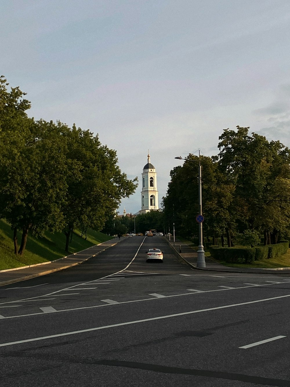 Un'auto che guida lungo una strada vicino a una torre dell'orologio