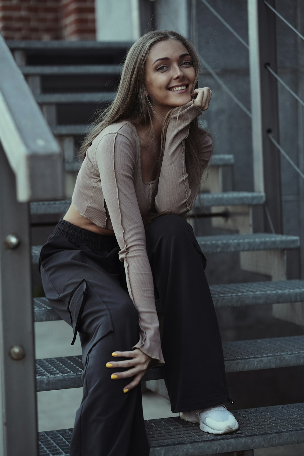 a woman sitting on a set of stairs posing for a picture