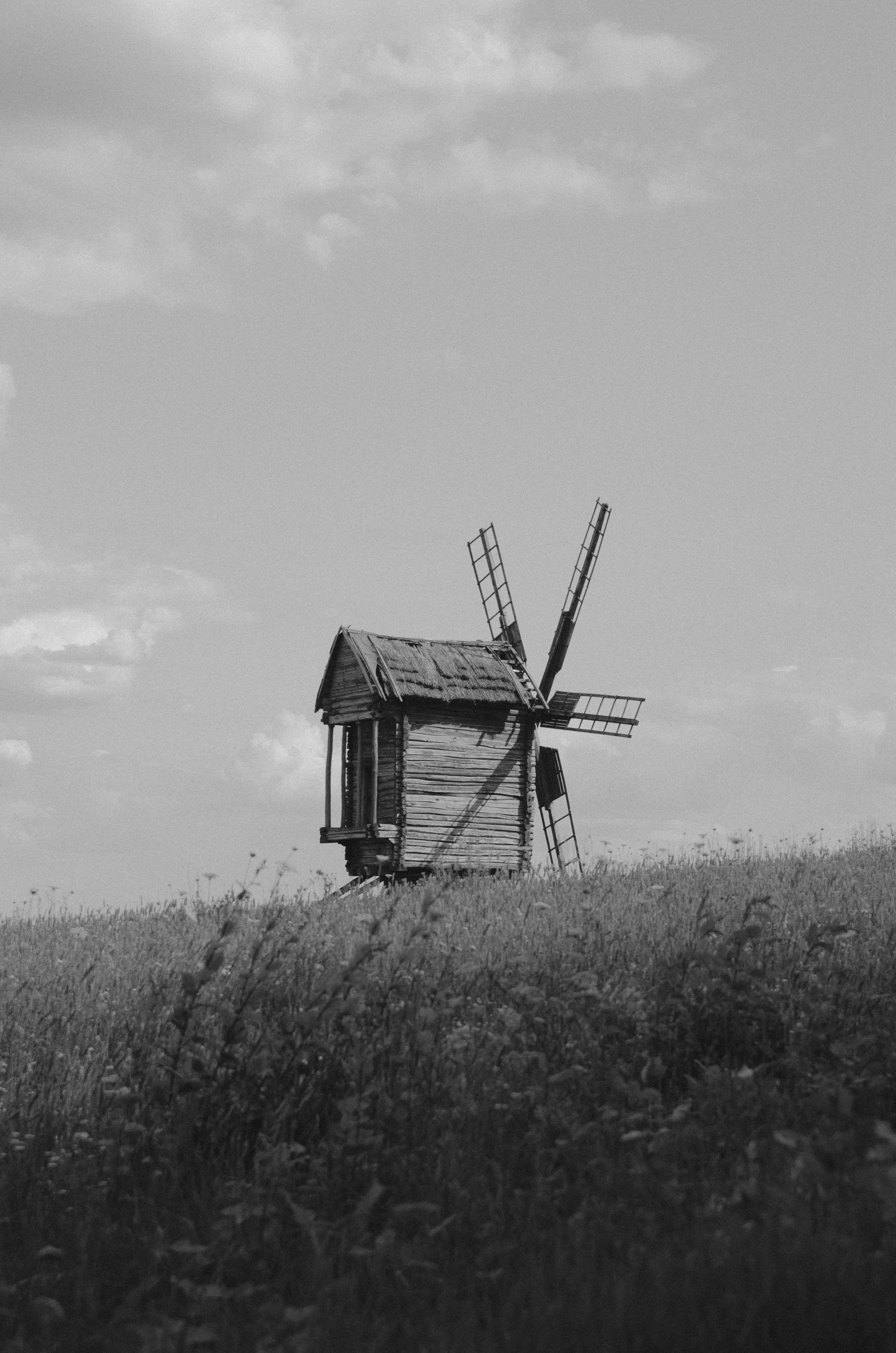 une photo en noir et blanc d’un moulin à vent dans un champ