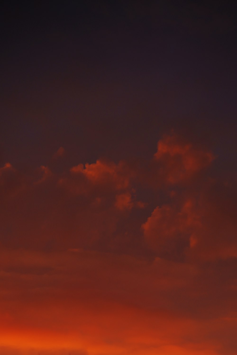 a plane flying in the sky at sunset