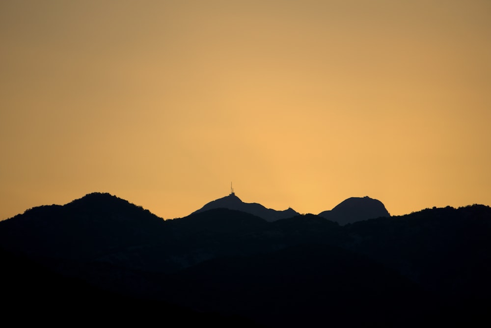 the silhouette of a mountain range at sunset