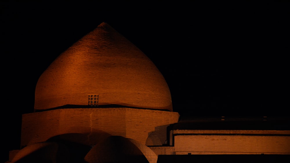 una gran cúpula con un reloj por la noche