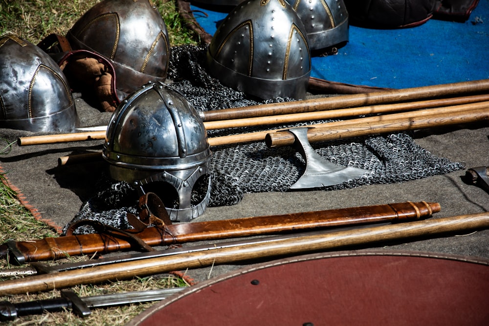 a bunch of helmets and swords laying on the ground