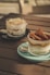 two desserts are sitting on a wooden table