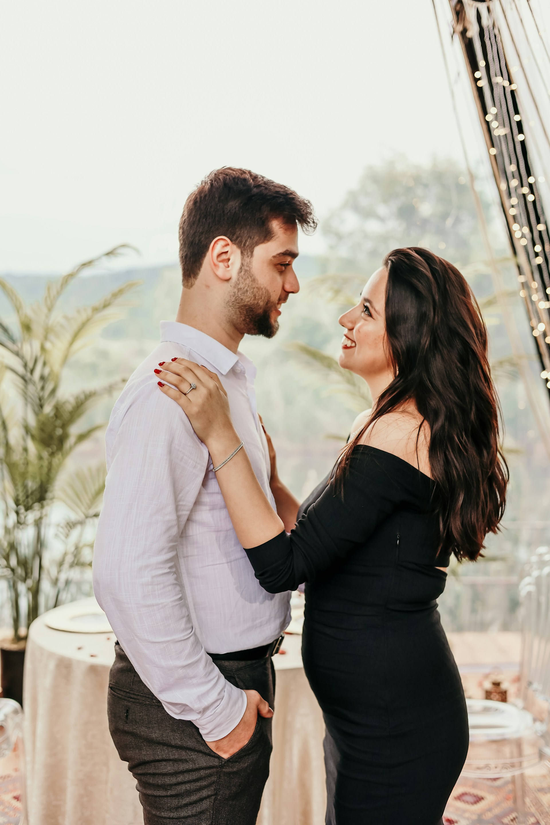 a man and woman standing next to each other in front of a table