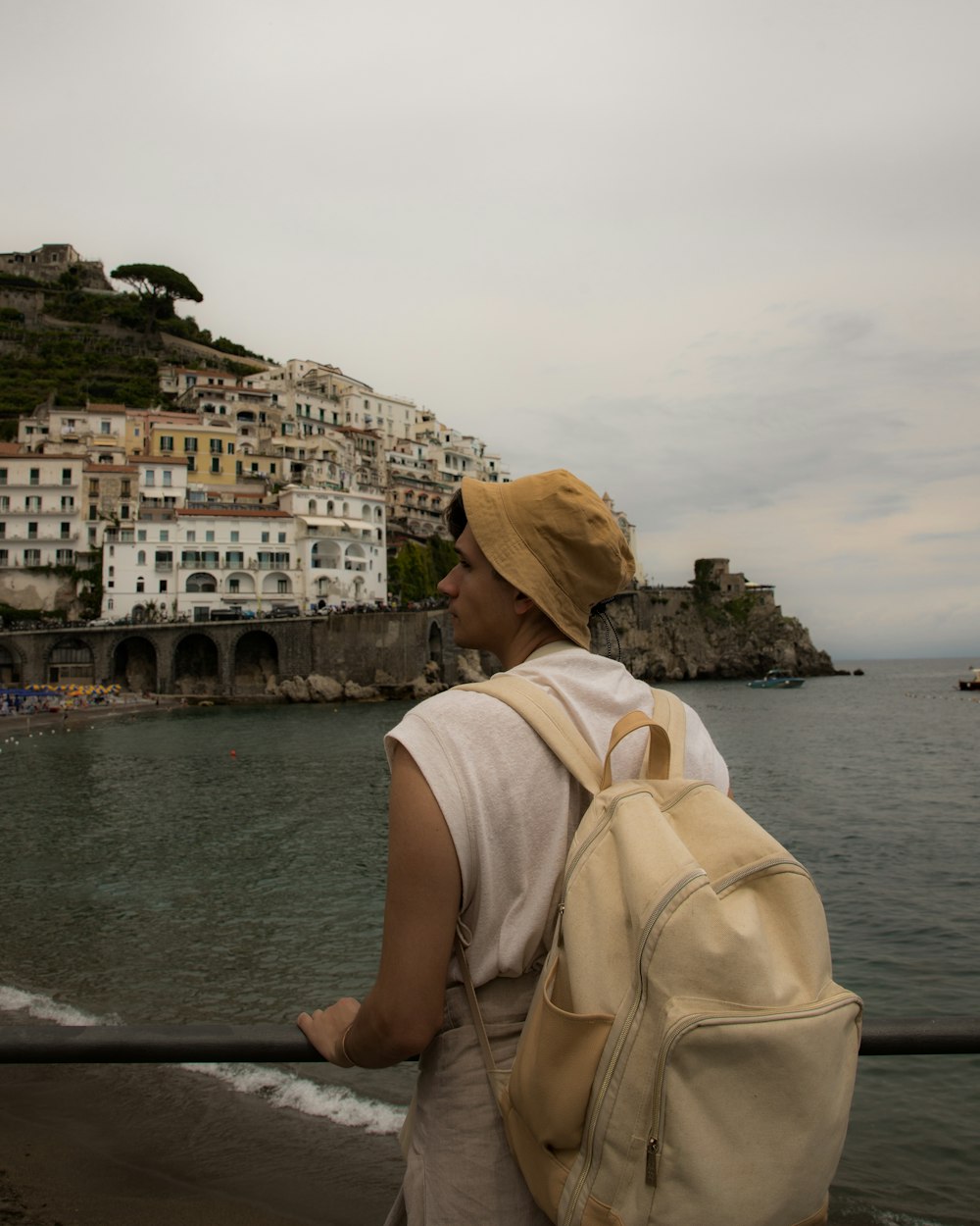 a woman with a backpack looking out over the water