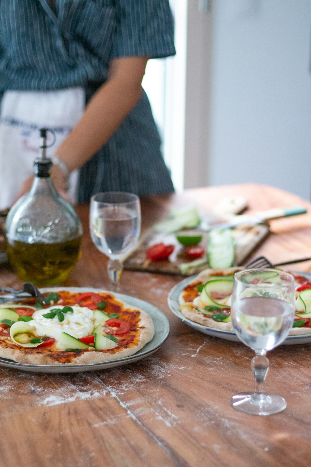 a table topped with a pizza covered in veggies