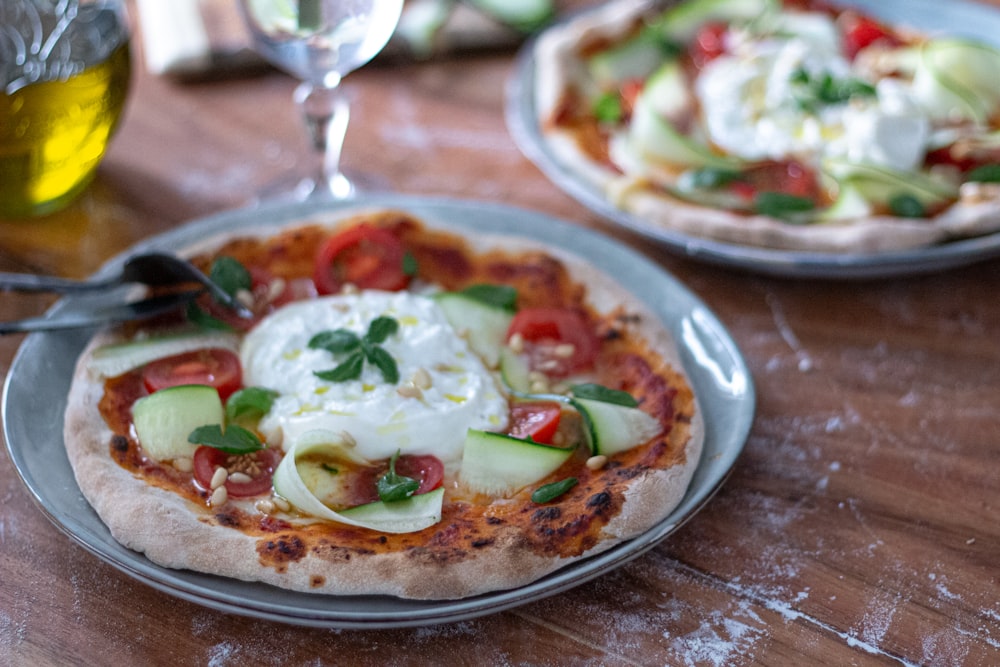 a couple of pizzas sitting on top of a wooden table