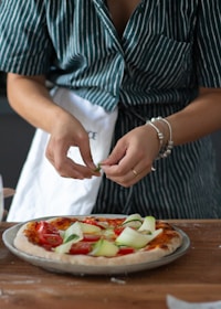 A chef preparing a pizza in a vibrant kitchen, showcasing fresh ingredients and culinary skills.